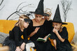 © zzzdim - Mother reads scary story to children, they are sitting on a couch.