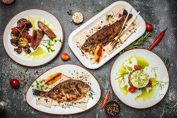 Set grilled trout and dorado. Fish dish fried fish fillet with vegetables on a light background. Ketogenic, keto or paleo diet lunch, Healthy food trend. top view. place for text