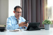 © WS Studio 1985 - Man using a laptop computer and phone at work in a office, online study, internet marketing, working from home, office workspace freelance concept