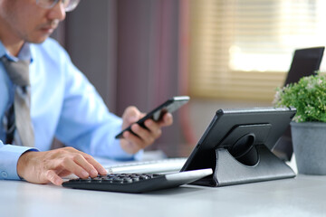 Poster - Businessman using calculator and laptop for making money math on table in office and business work, tax, accounting, statistics and analytical research concepts