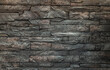 Soft light on pieces of Stone cladding wall. made of striped stacked slabs of natural brown rocks for walls texture and background, Copy space, Selective focus.