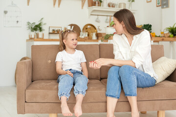 The trusting relationship of mom and daughter. Conversation of a woman with a little girl at home on the couch in the kitchen. Best friends happy motherhood weekend together with kid concept