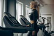 © Petro - Sporty woman running on treadmill at the gym