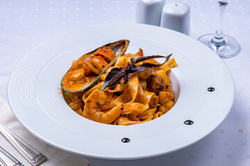 Wall Mural - Pasta with seafood on tomato sauce on white plate