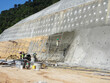 SELANGOR, MALAYSIA -MARCH 4: Construction workers are spraying liquid concrete onto the slope surface to form a retaining wall layer. It acts to prevent erosion on the slope surface.
