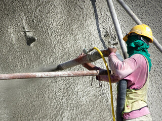 Wall Mural - SELANGOR, MALAYSIA -MARCH 4: Construction workers are spraying liquid concrete onto the slope surface to form a retaining wall layer. It acts to prevent erosion on the slope surface.
