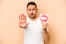 Hispanic Caucasian Man Holding A Forbidden Sign Isolated On Beige Background
