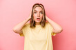 © Asier - Young caucasian woman isolated on pink background covering ears with hands trying not to hear too loud sound.