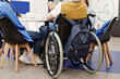 © Seventyfour - Back view at young college student in wheelchair participating in group discussion, copy space