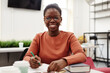© Seventyfour - Front view portrait of young black woman studying in college and smiling happily at camera