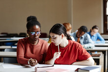 Front View Portrait Of Two Young Women Taking Notes While Studying In College Classroom, Copy Space
