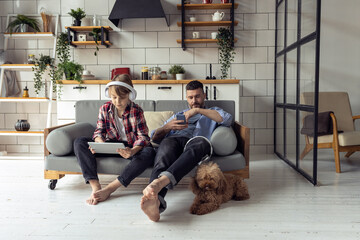 Handsome young father and his teenager son spending quality time together. Son playing on the tablet, gadget. Family time, having fun, enjoy. Fatherhood, parenting concept. Two generations