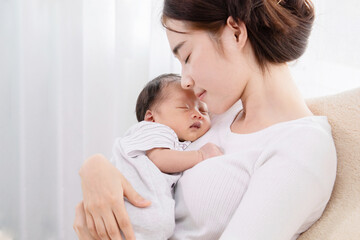 asian mother holding her newborn in arm and sleeping together with love and care, adorable baby in m