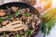 Frying pan with fried morel mushrooms and various spices and vegetables, sunbeam