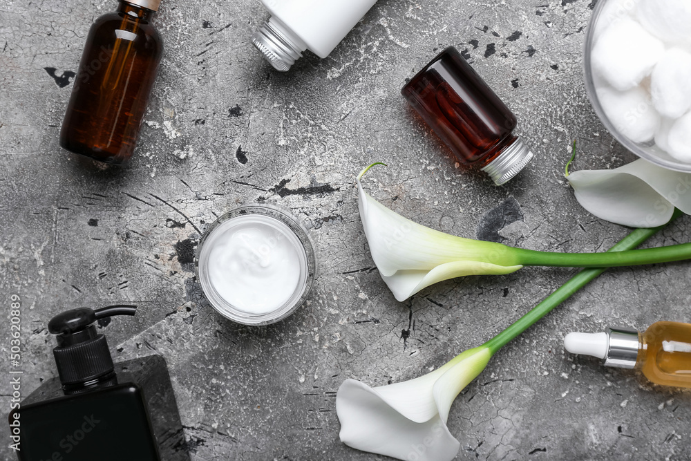 Cosmetic products and calla lilies on grunge background