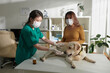 © DragonImages - Veterinary nurse giving medicine to labrador retriever dog lying on medical table during annual examination