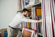 © Dusan Petkovic - A printing shop manager trying to pull out printing form for screen printing from storage.