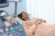 Happy pregnant female visiting women's doctor in the maternity center, doing ultrasound scan, worried about the health of the child, healthy motherhood concept