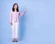 © Timeimage - Full length image of middle aged Asian woman on blue background
