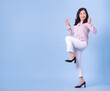 © Timeimage - Full length image of middle aged Asian woman on blue background