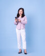 © Timeimage - Full length image of middle aged Asian woman on blue background