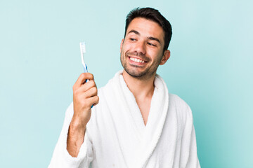 Wall Mural - young hispanic man. bathrobe and teethbrush concept