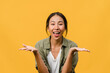 © tirachard - Young Asia lady feel happiness with positive expression, joyful surprise funky, dressed in casual cloth and looking at camera isolated on yellow background. Happy adorable glad woman rejoices success.