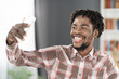 © Svyatoslav Lypynskyy - Smiling African American student or freelancer use smartphone having video call or taking selfie. Portrait of happy man with phone in hand looking at smartphone camera. Social media concept
