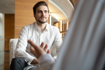 Wall Mural - Business meeting. Two business people sitting in front of each other in the office while discussing something.