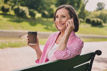 Poster - Photo of cute shiny lady pensioner wear pink shirt taking out coffee talking modern gadget outdoors countryside garden