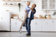 © Prostock-studio - Romantic elderly man and woman dancing at kitchen