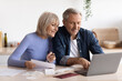 © Prostock-studio - Happy senior couple paying bills online, using computer