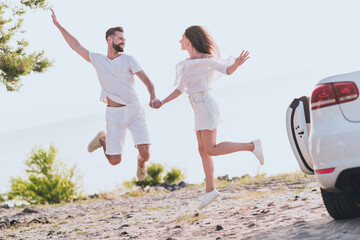 Poster - Photo of cute charming boyfriend girlfriend dressed casual outfit jumping holding arms driving cabriolet outdoors countryside