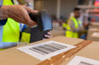© Wavebreak Media - Cropped hand of asian mature male worker scanning barcode on cardboard box with reader
