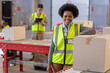 © Wavebreak Media - Portrait of smiling young woman standing by cardboard box and asian mature man working in background