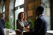 © Maskot - Businesswoman shaking hand with businessman at seminar in convention center