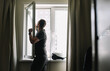 © paralisart - Man washing and cleaning window at home. Housework and housekeeping, home hygiene