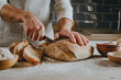 © lithiumphoto - Young man in apron cutting homemade bread