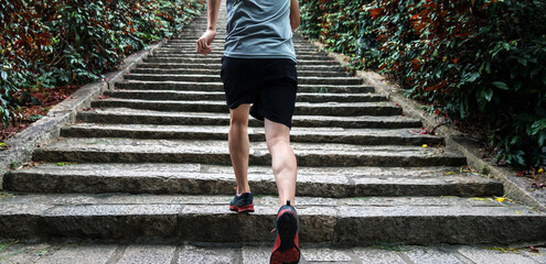 Wall Mural - Low section of runner athlete running on staircase