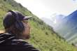 © Chepko Danil - Young man in headphones listening music in nature and at the mountain