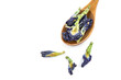 Dried butterfly pea flowers in a wooden spoon on white background. Blue flower for tea.