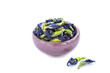 A handful of dried butterfly pea flowers in small cup on a white background. Blue flower for tea.