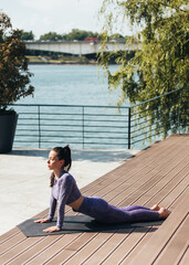 Poster - Young woman practicing yoga outdoor. Female happiness.  Athlete training stretching of all muscle groups