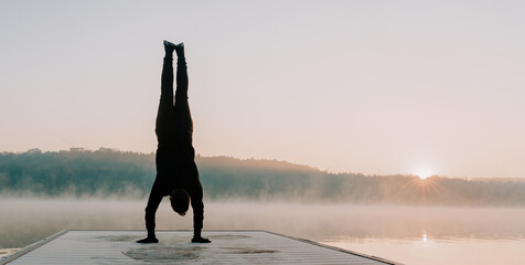 Man doing yoga in the morning at the sunrise. Productive healthy person