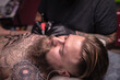 © Mr. Prof - Tattoo specialist makes cool tattoo in tattoo parlor
