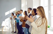 Multiracial smiling group of business people standing in line and applauding at the office against big window on background - Business company team, standing ovation after a successful meeting