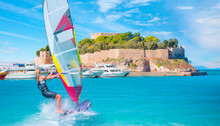 Windsurfer Surfing The Wind On Waves In Kusadasi - Pigeon Island With A "Pirate Castle" Kusadasi Harbor, Aegean Coast Of Turkey