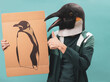 ©  Yistocking - An activist posing in a penguin mask with a banner of a melting penguin on a blue background.climate change concept.