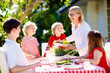 © famveldman - Family eating outdoor. Garden summer fun.