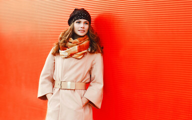 Portrait of beautiful young woman wearing coat and scarf in the city